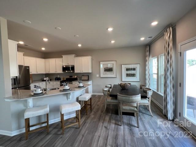 5787 Soft Shell Drive, Unit 306 Lancaster, SC 29720 - Photo 4 of 18 a living room with stainless steel appliances kitchen island granite countertop furniture wooden floor and a view of kitchen
