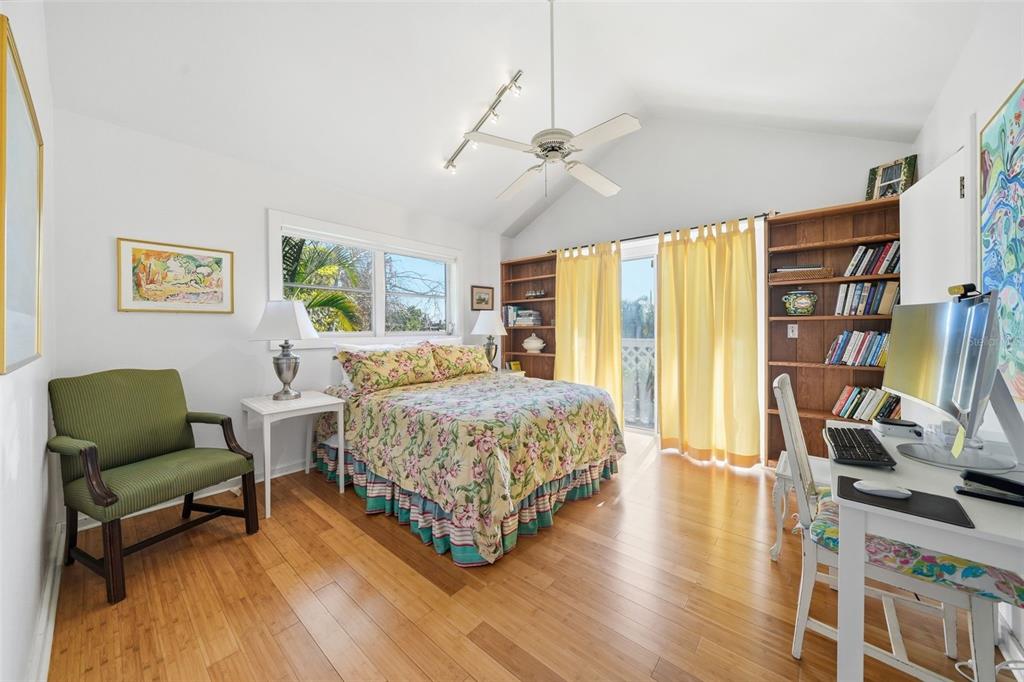 700 Lands End Drive Longboat Key, FL 34228 - Photo 29 of 70 a bedroom with a bed a bookshelf and a large window
