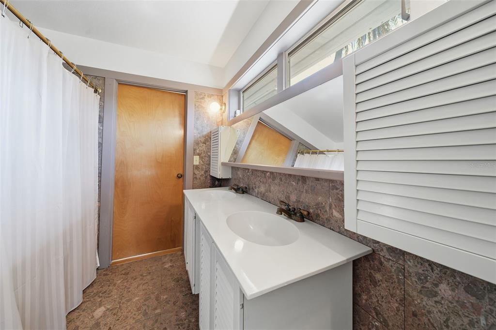 700 Lands End Drive Longboat Key, FL 34228 - Photo 31 of 70 a bathroom with a sink a mirror and shower