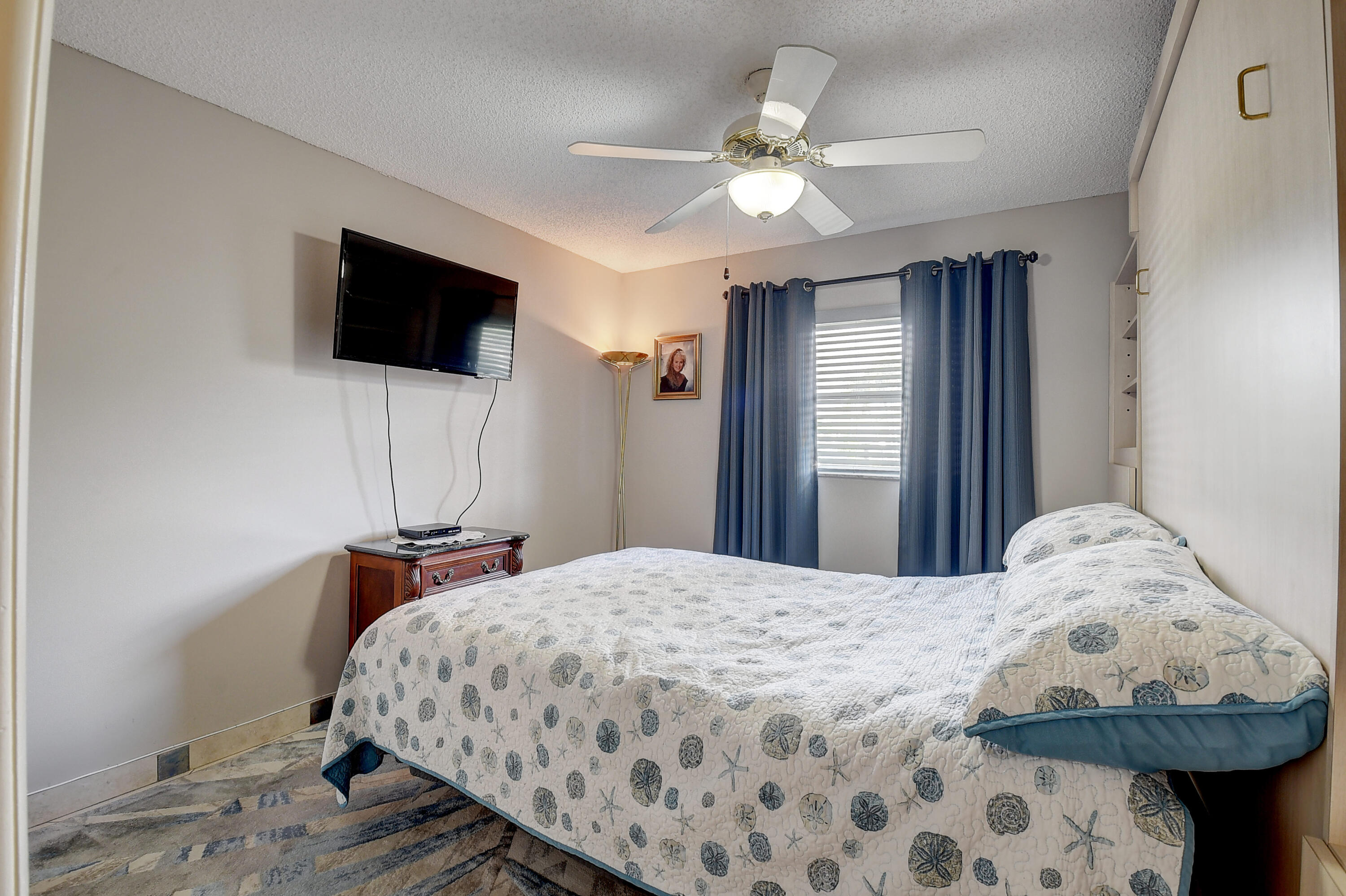 8936 Rheims Road Boca Raton, FL 33496 - Photo 18 of 42 a bedroom with a bed a flat screen tv and a chandelier