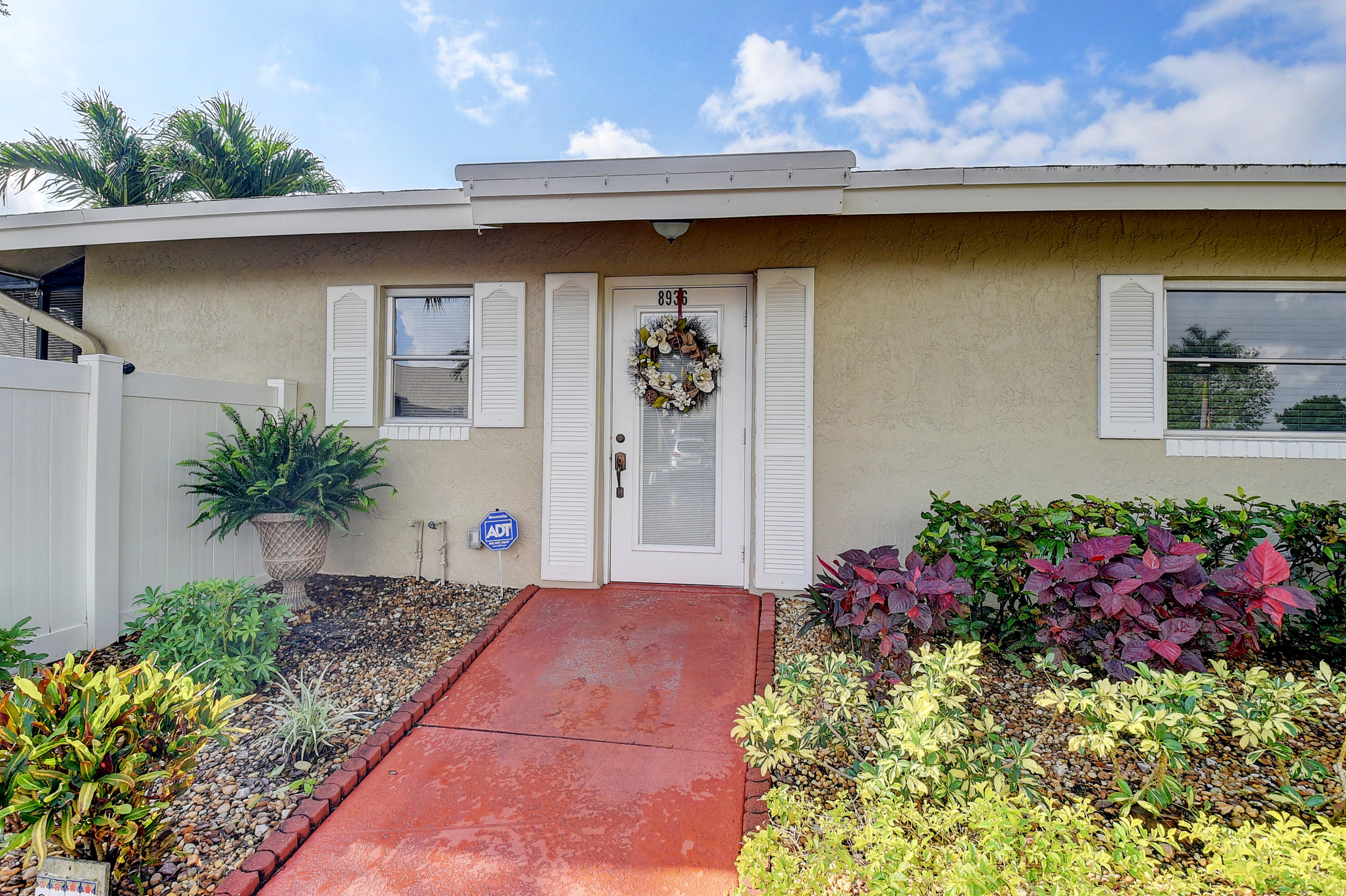 8936 Rheims Road Boca Raton, FL 33496 - Photo 3 of 42 a front view of a house with a yard