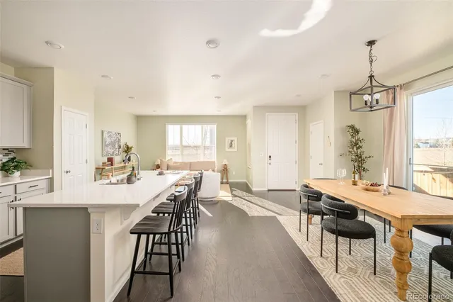 a view of a dining room and livingroom with furniture wooden floor a chandelier