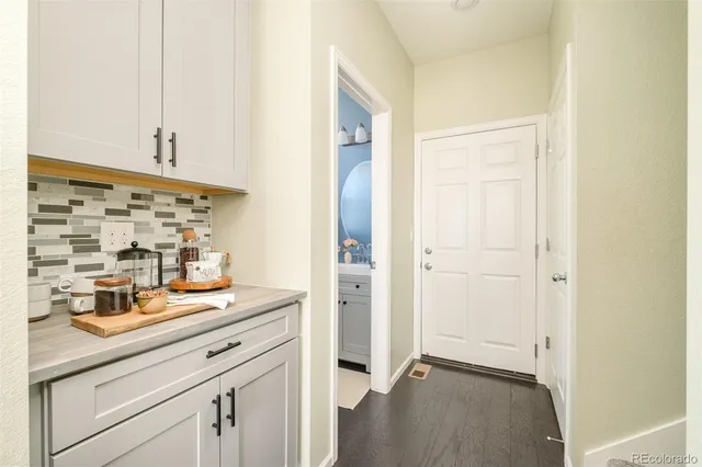 a view of a hallway with wooden floor and closet
