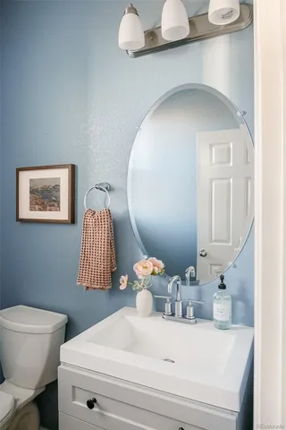 a bathroom with a sink mirror and toilet