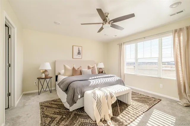 a spacious bedroom with a bed a window and a chandelier