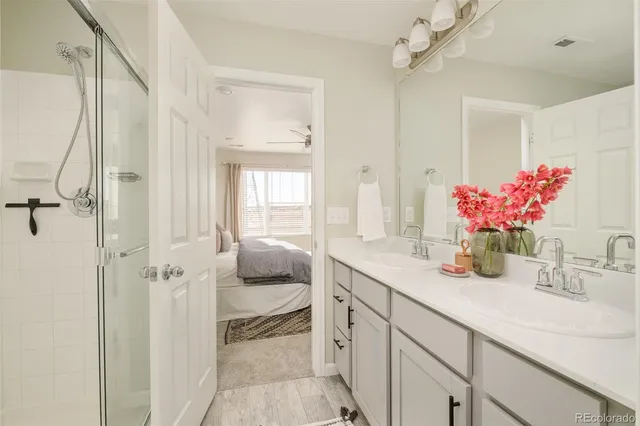 a bathroom with a granite countertop sink a shower and a mirror