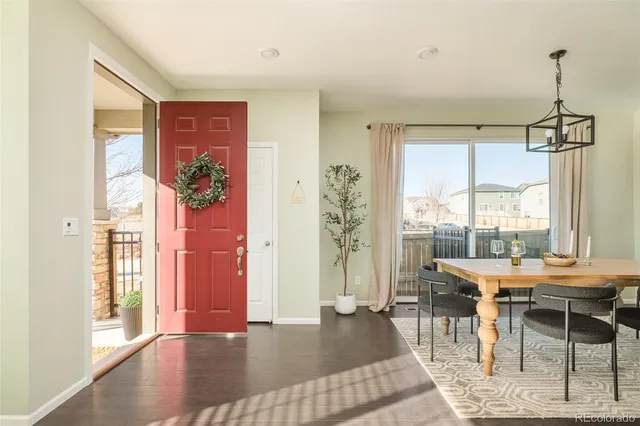 a dining room with furniture a chandelier and wooden floor