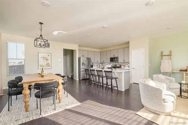 a living room with furniture a dining table and a chandelier