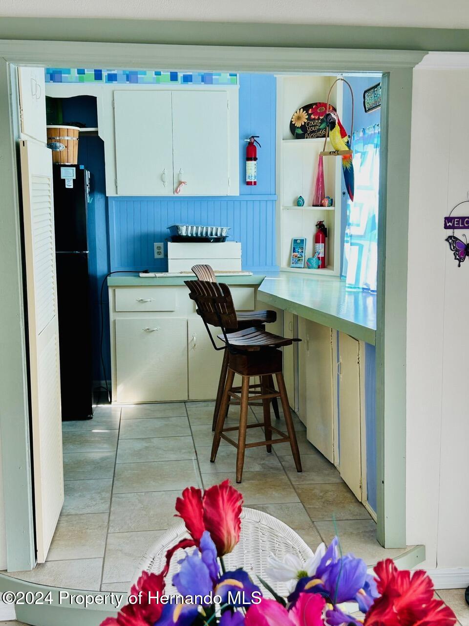 5332 Circle Drive Weeki Wachee, FL 34607 - Photo 21 of 27 a kitchen with a refrigerator and cabinets
