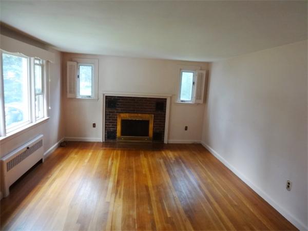 3 Girdler Road Marblehead, MA 01945 - Photo 2 of 8 an empty room with wooden floor fireplace and windows