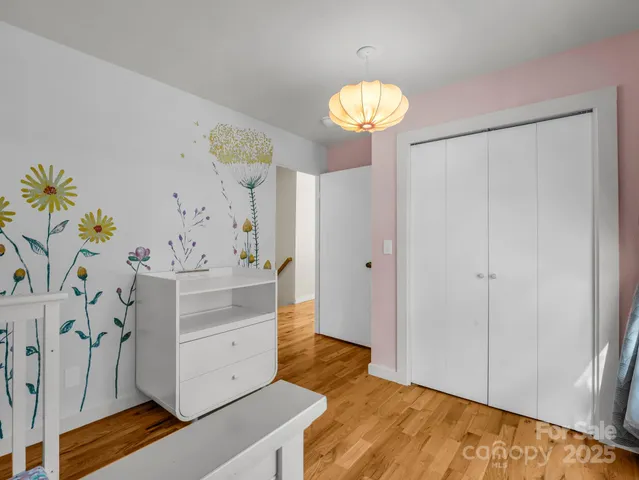 a view of a hallway with front door and wooden floor
