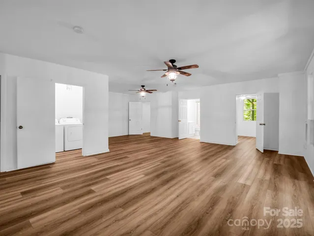 a view of empty room with window and wooden floor