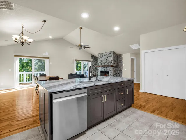 a kitchen with stainless steel appliances granite countertop a sink a stove and a wooden floors