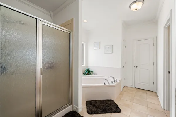 a spacious bedroom with a bed and a chandelier