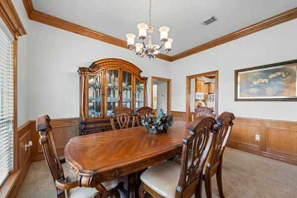 a living room with furniture a flat screen tv and kitchen view