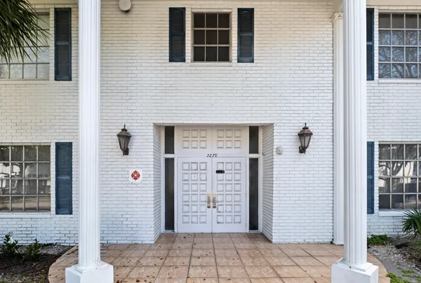 a view of a brick house with large windows