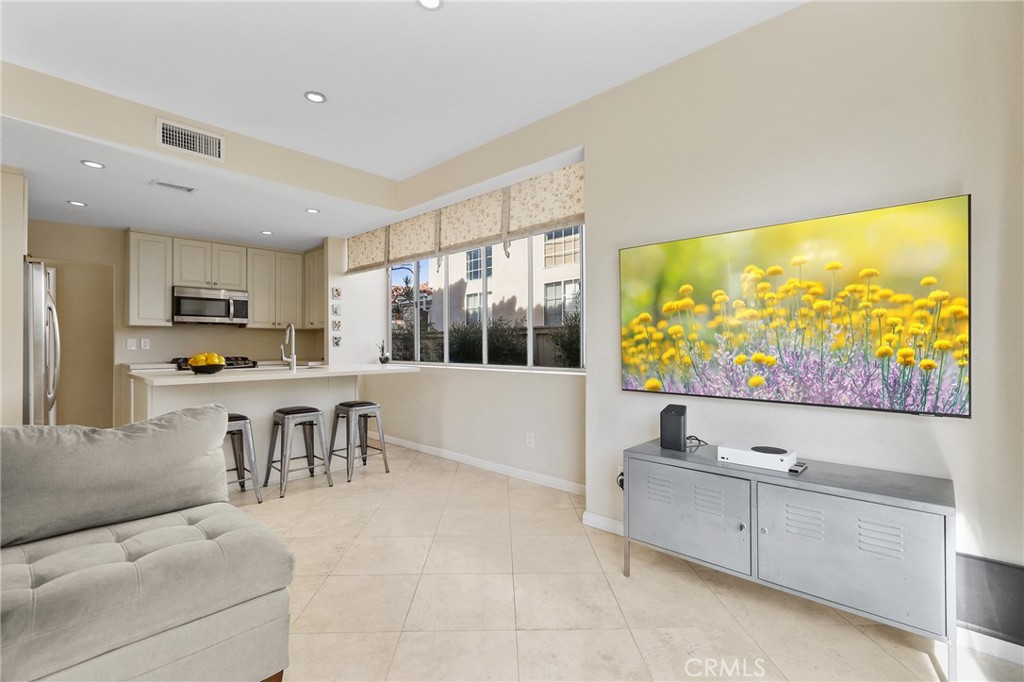2 Bormes Irvine, CA 92614 - Photo 11 of 69 a living room with stainless steel appliances kitchen island granite countertop furniture and a flat screen tv