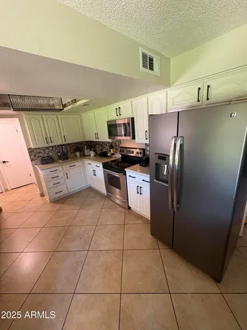 a kitchen with stainless steel appliances granite countertop a refrigerator and a sink