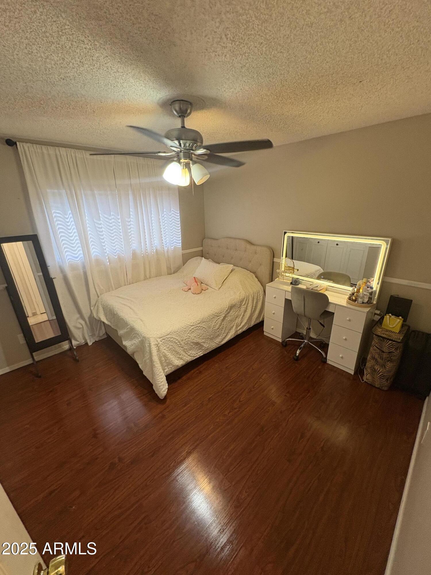 5021 West Echo Lane Glendale, AZ 85302 - Photo 6 of 7 a spacious bedroom with a bed and a chandelier