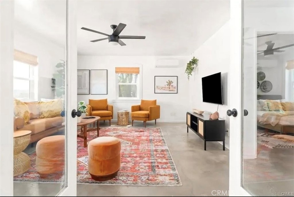 64975 Sun Oro Road Joshua Tree, CA 92252 - Photo 13 of 52 a living room with furniture and a flat screen tv
