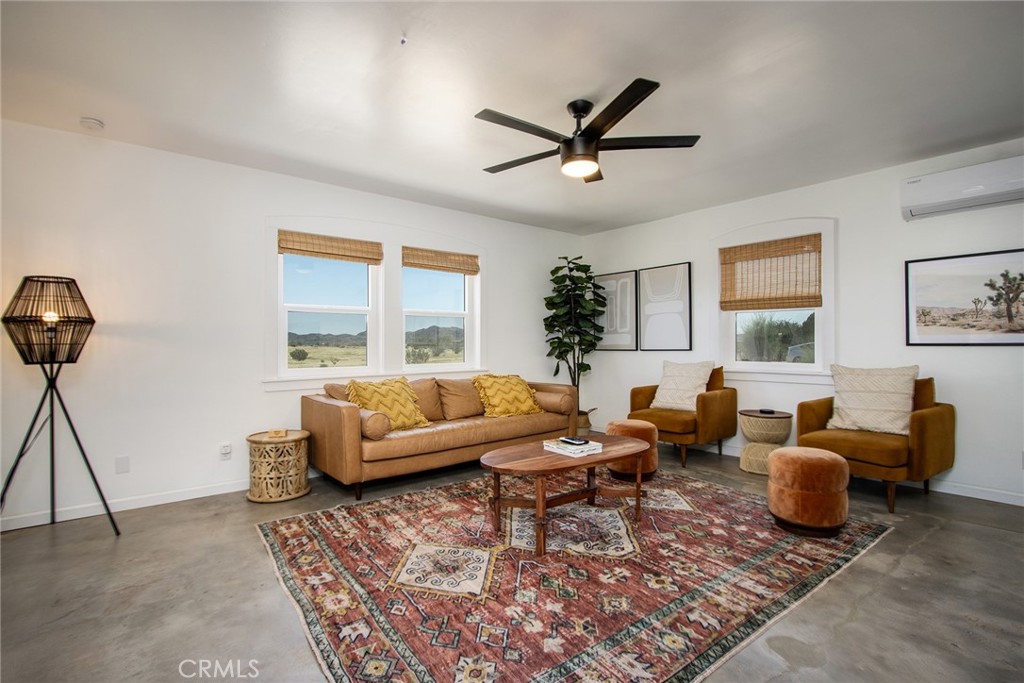 64975 Sun Oro Road Joshua Tree, CA 92252 - Photo 14 of 52 a living room with furniture a rug and a window