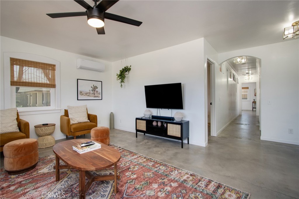 64975 Sun Oro Road Joshua Tree, CA 92252 - Photo 16 of 52 a living room with furniture and a flat screen tv
