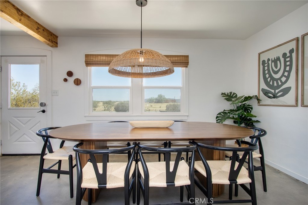 64975 Sun Oro Road Joshua Tree, CA 92252 - Photo 18 of 52 a view of a dining room with furniture window and wooden floor