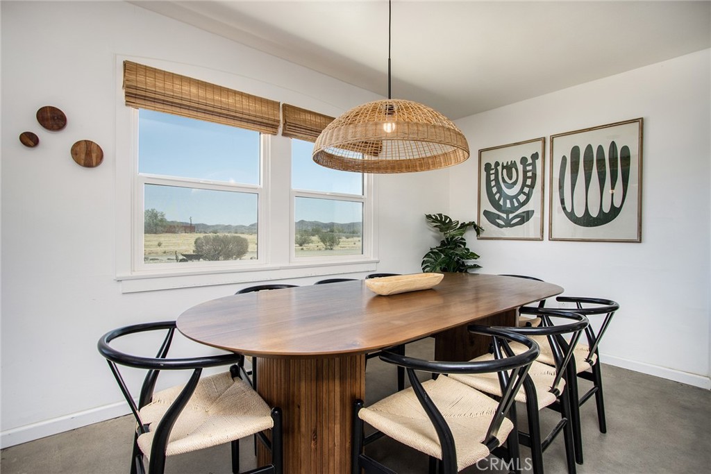 64975 Sun Oro Road Joshua Tree, CA 92252 - Photo 19 of 52 a view of a dining room with furniture window and wooden floor