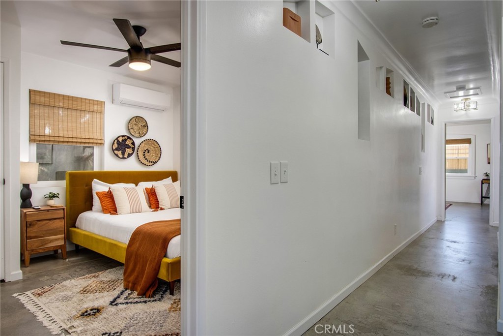 64975 Sun Oro Road Joshua Tree, CA 92252 - Photo 25 of 52 a bedroom with a bed and a chandelier