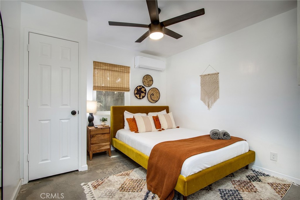 64975 Sun Oro Road Joshua Tree, CA 92252 - Photo 26 of 52 a bedroom with a bed and a painting on the wall