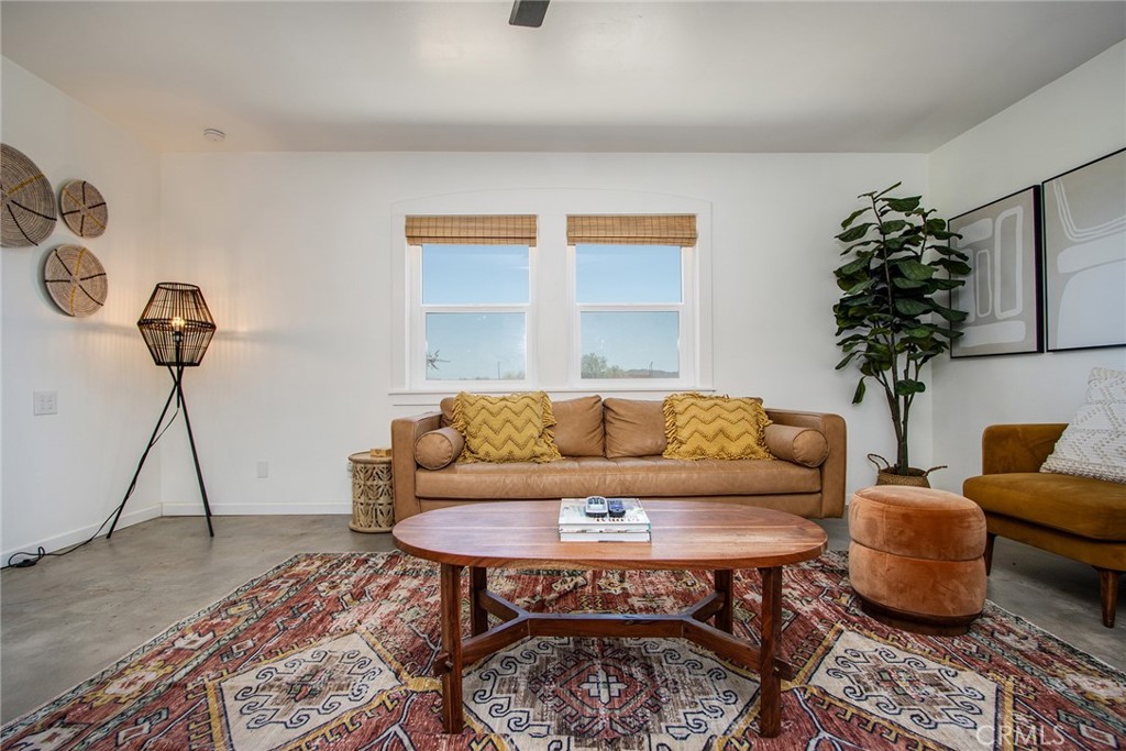 64975 Sun Oro Road Joshua Tree, CA 92252 - Photo 4 of 52 a living room with furniture a rug and a potted plant