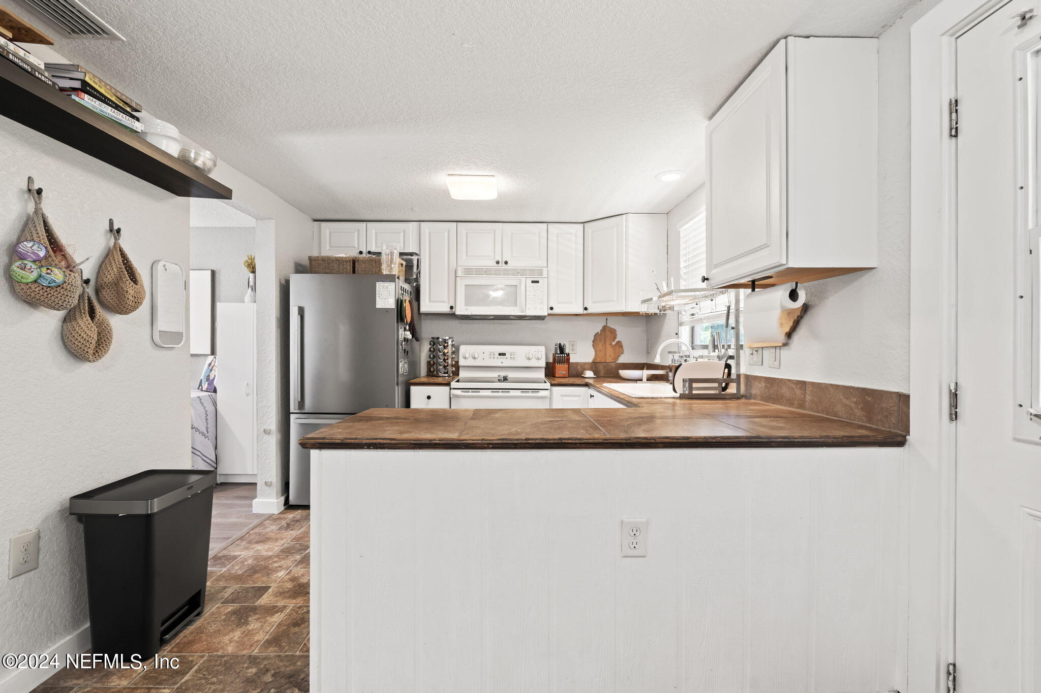13548 Chauny Road Jacksonville, FL 32246 - Photo 11 of 55 a kitchen with stainless steel appliances granite countertop a refrigerator a sink and white cabinets