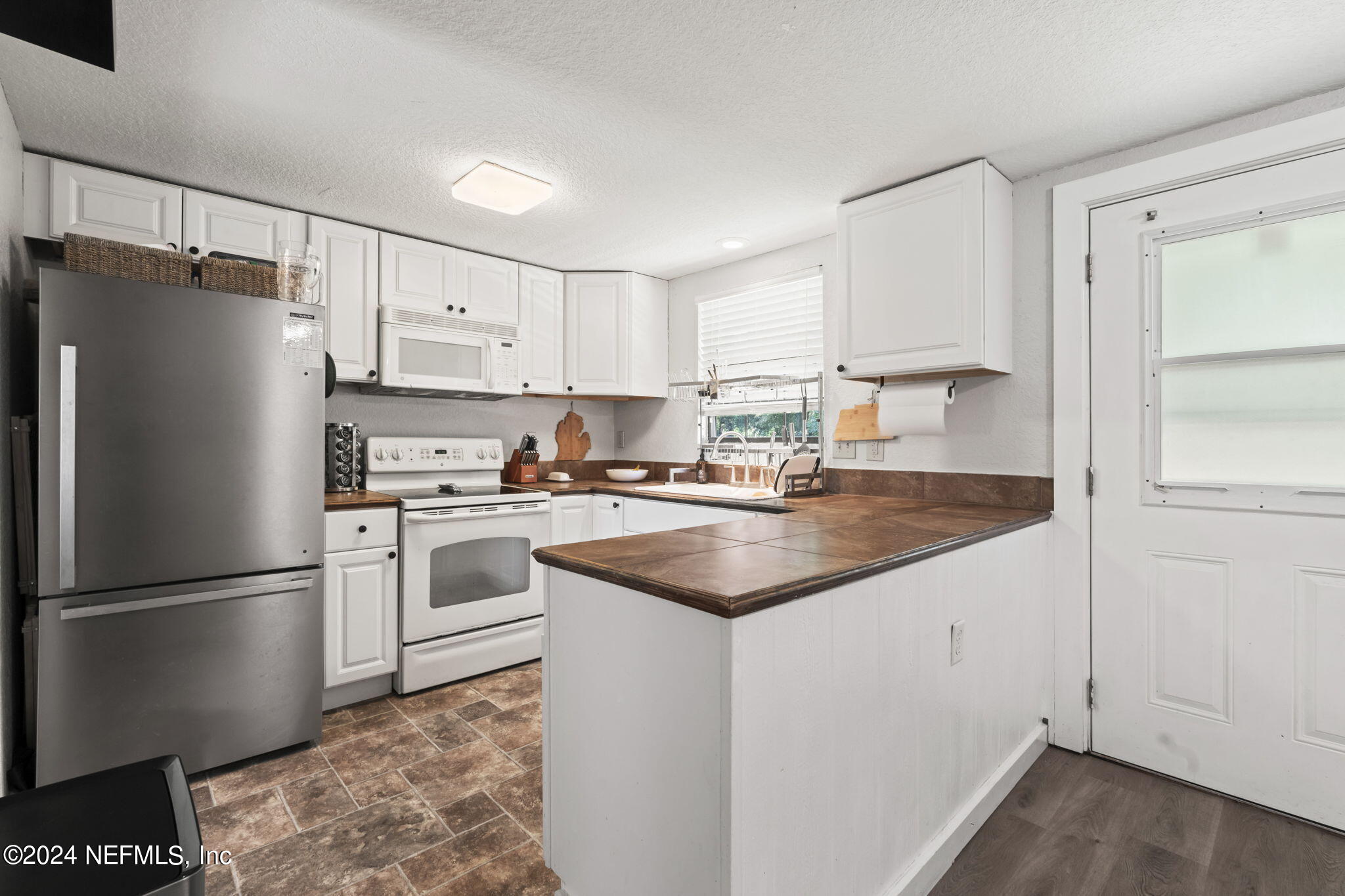 13548 Chauny Road Jacksonville, FL 32246 - Photo 12 of 55 a kitchen with white cabinets and white appliances