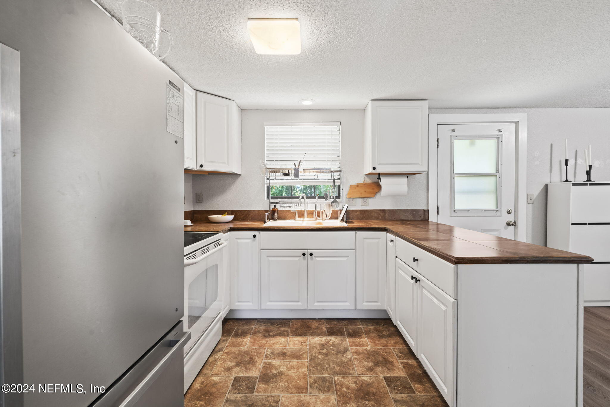 13548 Chauny Road Jacksonville, FL 32246 - Photo 13 of 55 a kitchen with granite countertop white cabinets and white appliances
