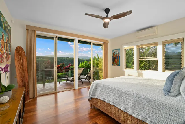 a bedroom with a large bed and a large window with wooden floor