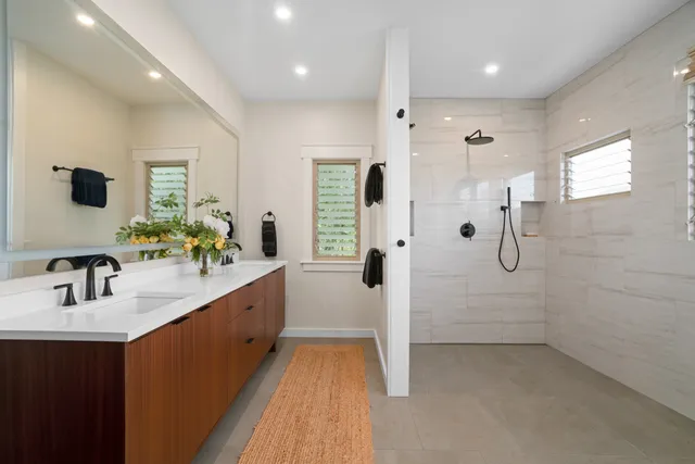 a bathroom with a double vanity sink a mirror and shower