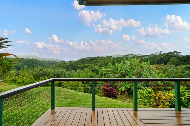 a view of a balcony with wooden floor & fence