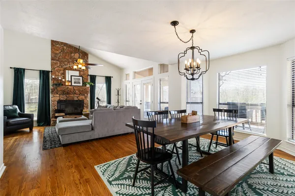 a view of a dining room with furniture a rug and wooden floor