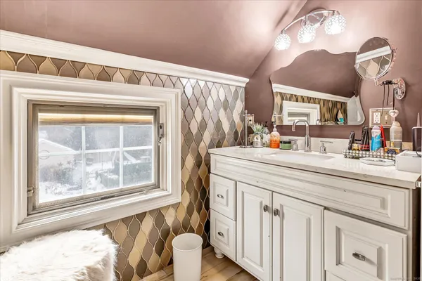 a bathroom with a sink a mirror and a window