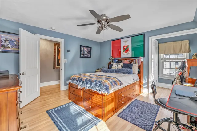 a bedroom with a large bed a flat screen tv and windows