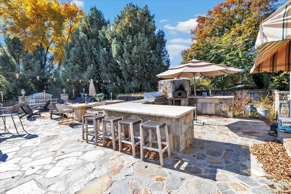 a view of a patio with furniture and table under an umbrella