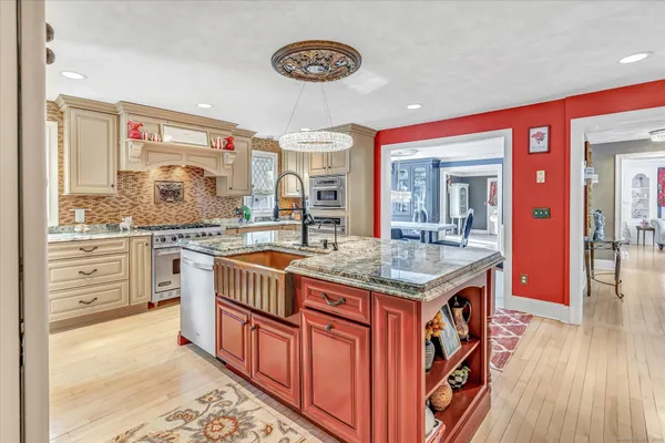 a kitchen with granite countertop a stove cabinets and wooden floor