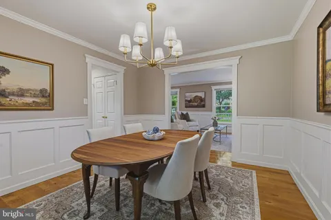 a kitchen with stainless steel appliances granite countertop a stove a refrigerator a kitchen island a table and chairs in it