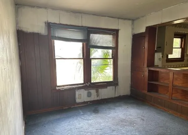 a view of an empty room with window and bathroom