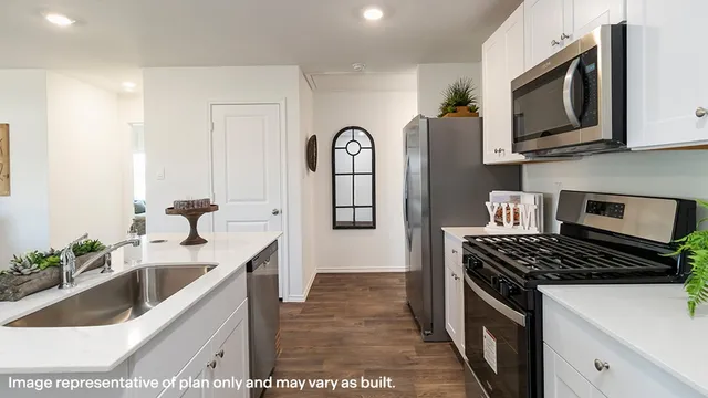 a kitchen with stainless steel appliances granite countertop a sink stove and cabinets