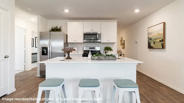 a kitchen with stainless steel appliances granite countertop a sink a stove a refrigerator and a microwave