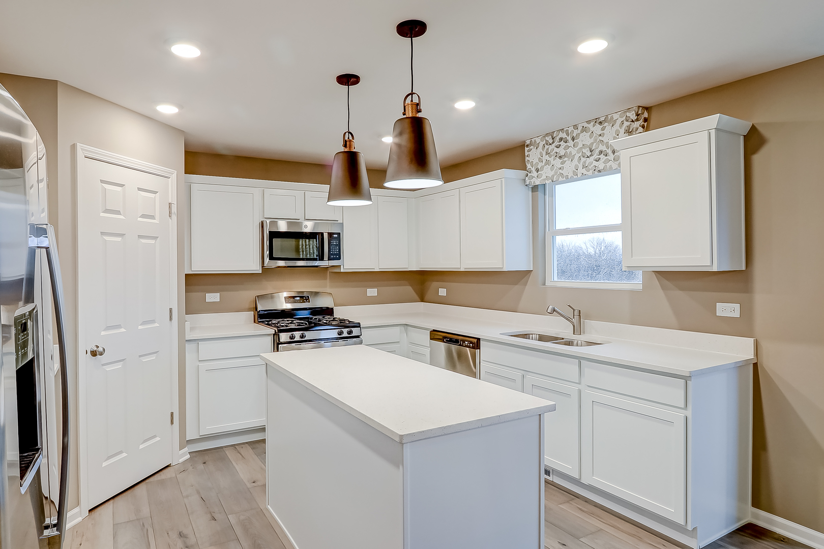 496 Endicott Road South Elgin, IL 60177 - Photo 11 of 33 a kitchen with a sink a stove a refrigerator and white cabinets