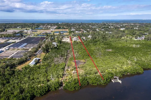 an aerial view of residential houses with outdoor space and trees