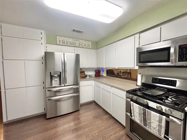 a kitchen with sink cabinets and wooden floor