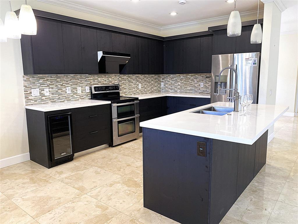 4375 Foxtail Lane Weston, FL 33331 - Photo 15 of 84 a kitchen with stainless steel appliances kitchen island granite countertop a sink stove and refrigerator